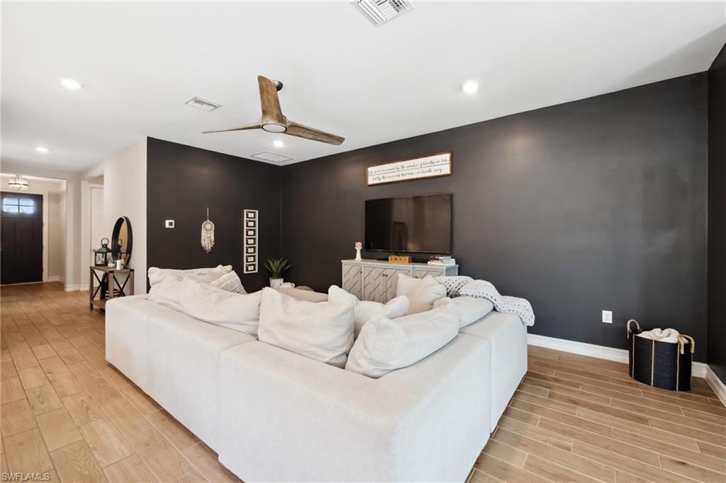 Living area with wood tiled floors, ceiling fan, and recessed lighting