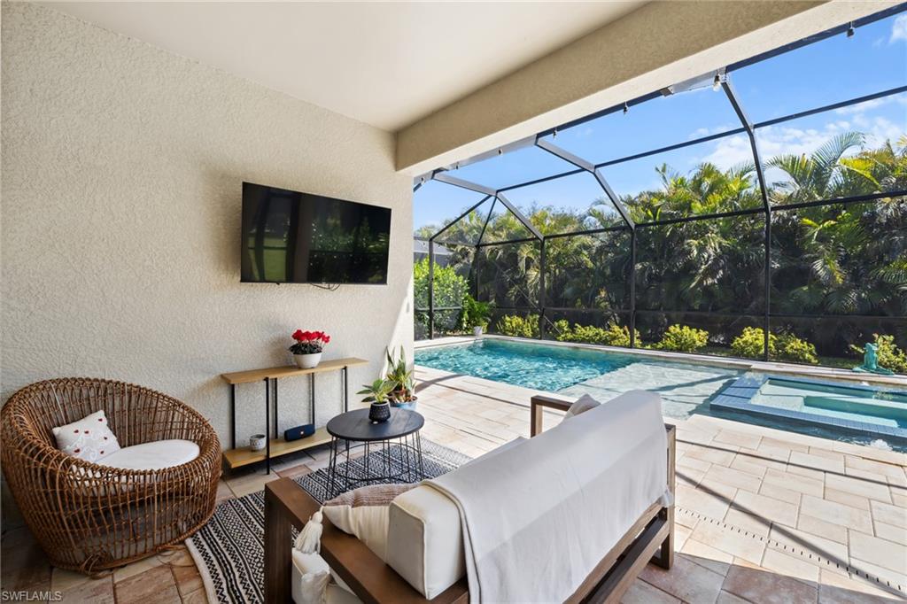 Outdoor pool with a patio area, a sunroom, glass enclosure, and an outdoor hangout area