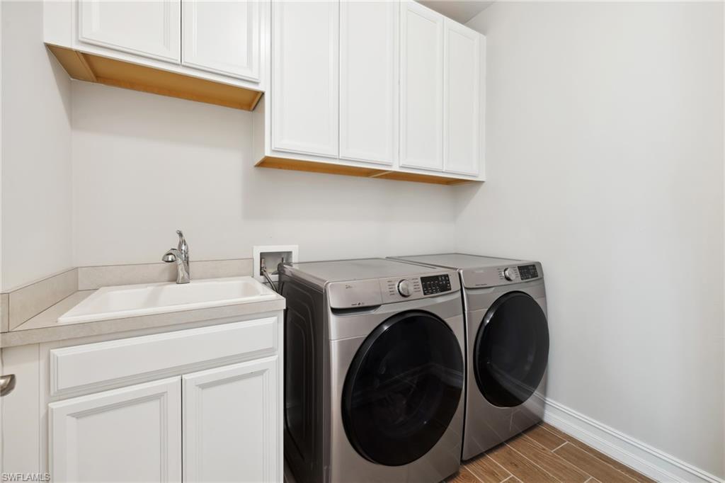 Laundry room featuring cabinet space, wood tiled floors, and separate washer and dryer