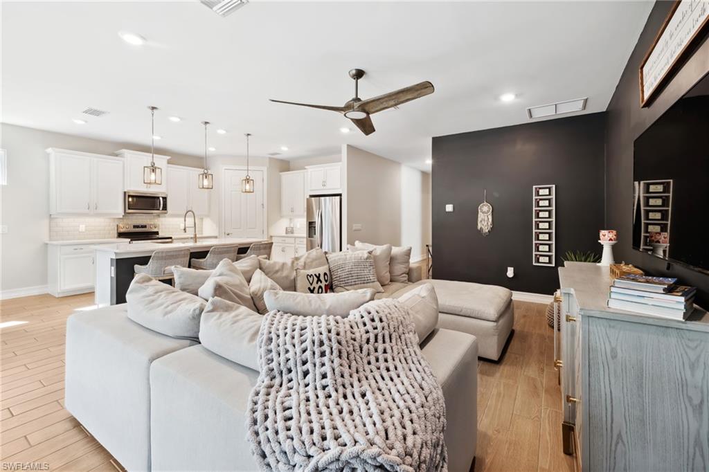 Living area featuring ceiling fan and light wood-type flooring