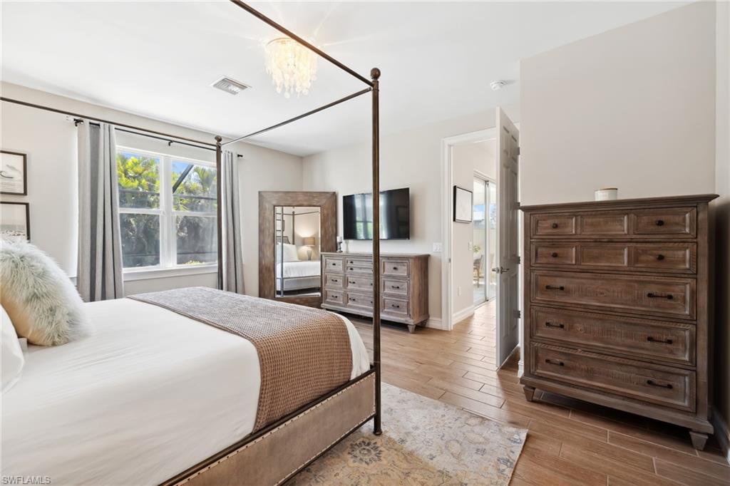 Bedroom with wood tiled floors and a chandelier