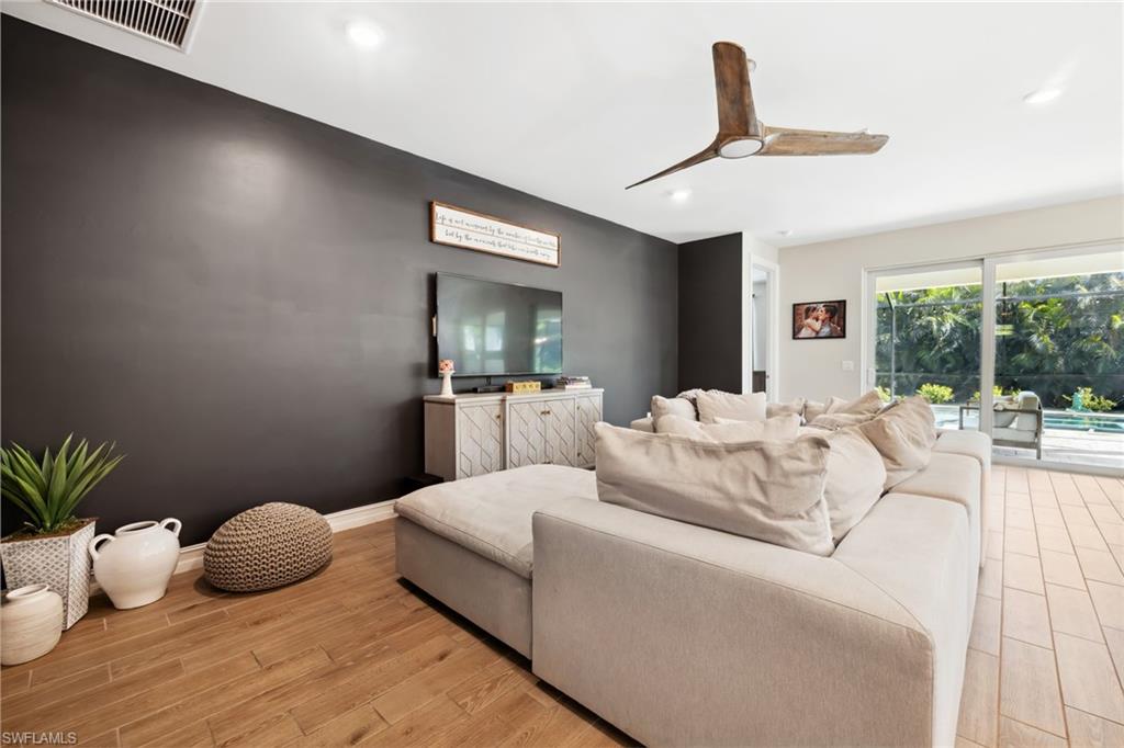 Living area with ceiling fan, light wood-style flooring, and recessed lighting