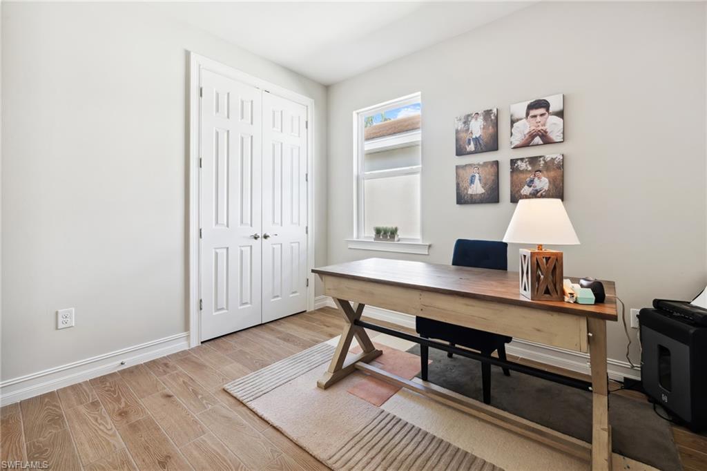 Office with light wood-type flooring and baseboards