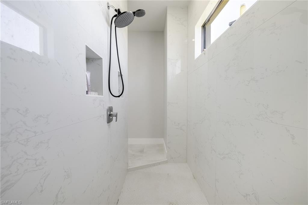 Bathroom featuring a marble finish shower