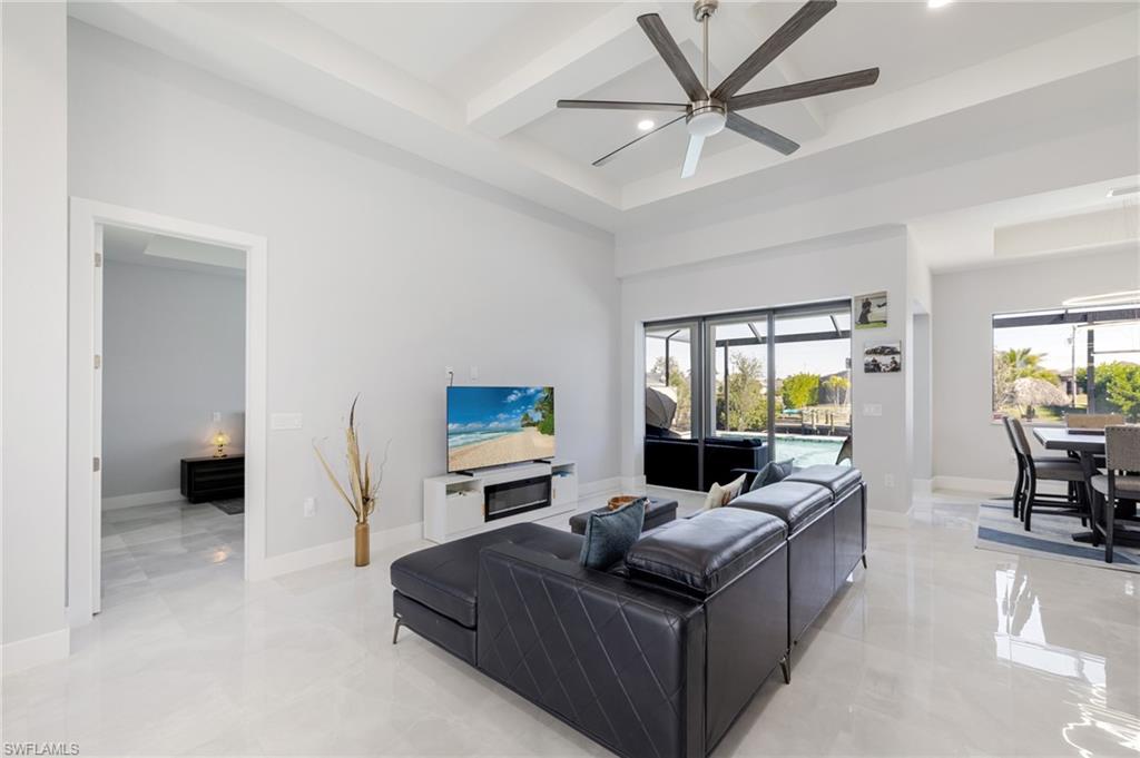 Living room featuring beamed ceiling, recessed lighting, a high ceiling, a ceiling fan, and coffered ceiling