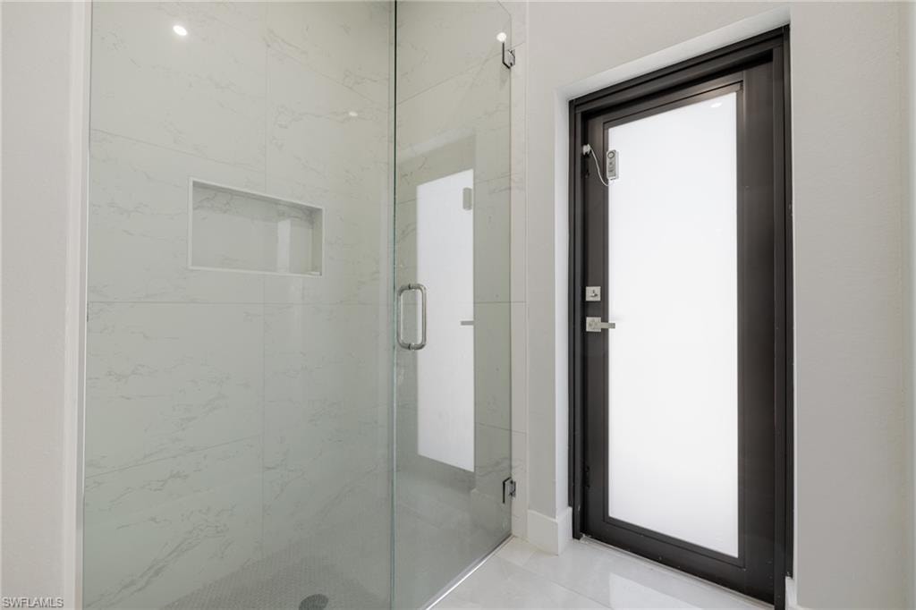 Full bath with a marble finish shower