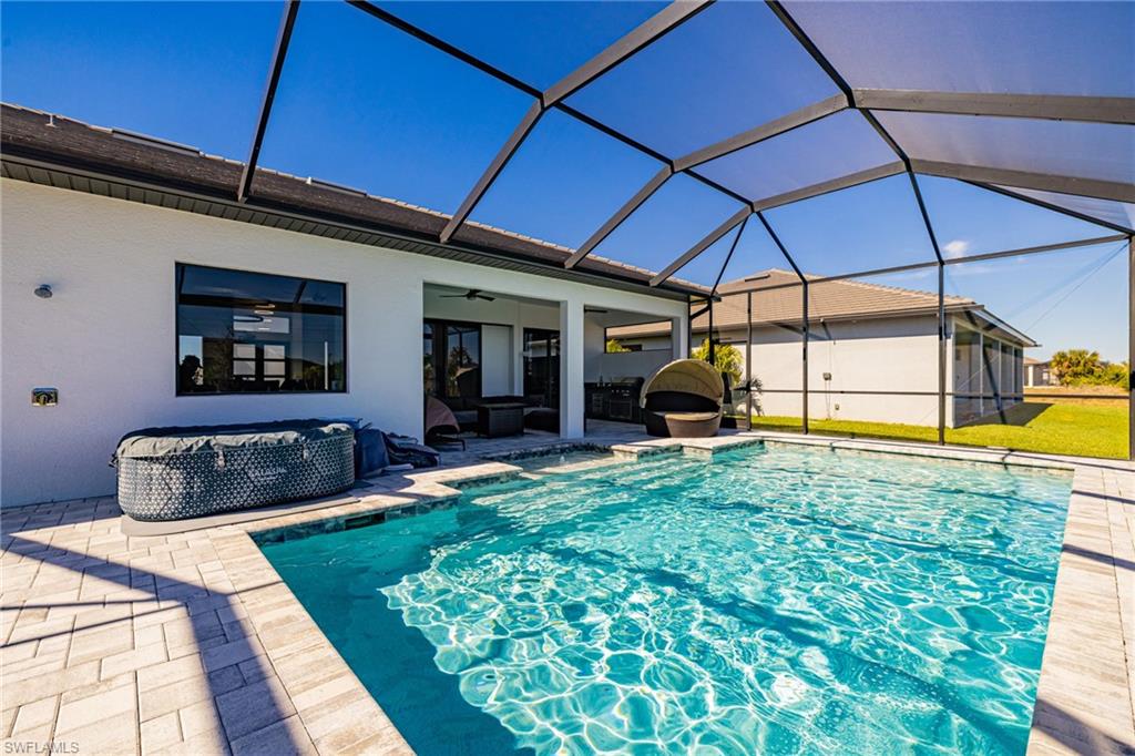 Swimming pool with glass enclosure, a sunroom, and a patio