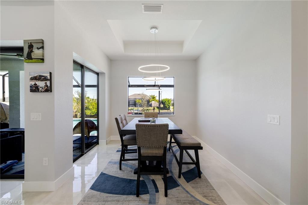 Dining room with a raised ceiling and baseboards