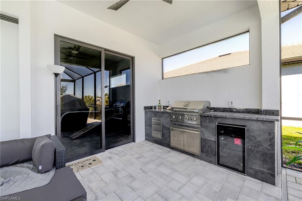 View of patio / terrace featuring an outdoor kitchen, beverage cooler, and a ceiling fan