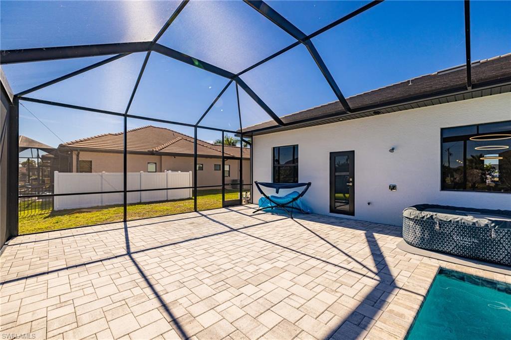 View of patio featuring a lanai, a sunroom, and a jacuzzi