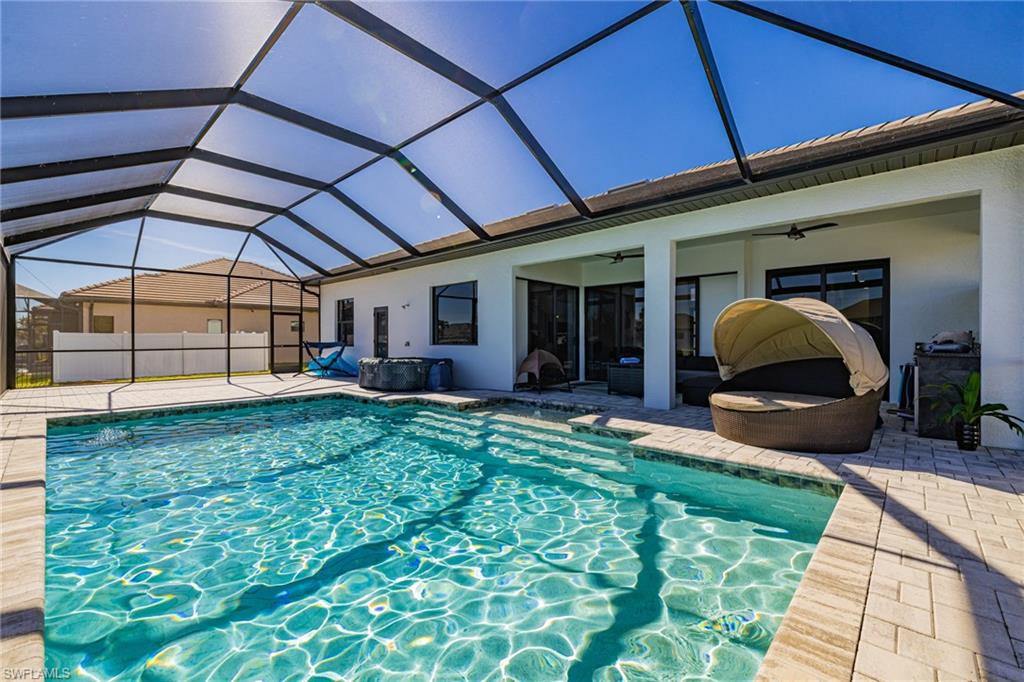 View of swimming pool featuring a sunroom, glass enclosure, and a patio