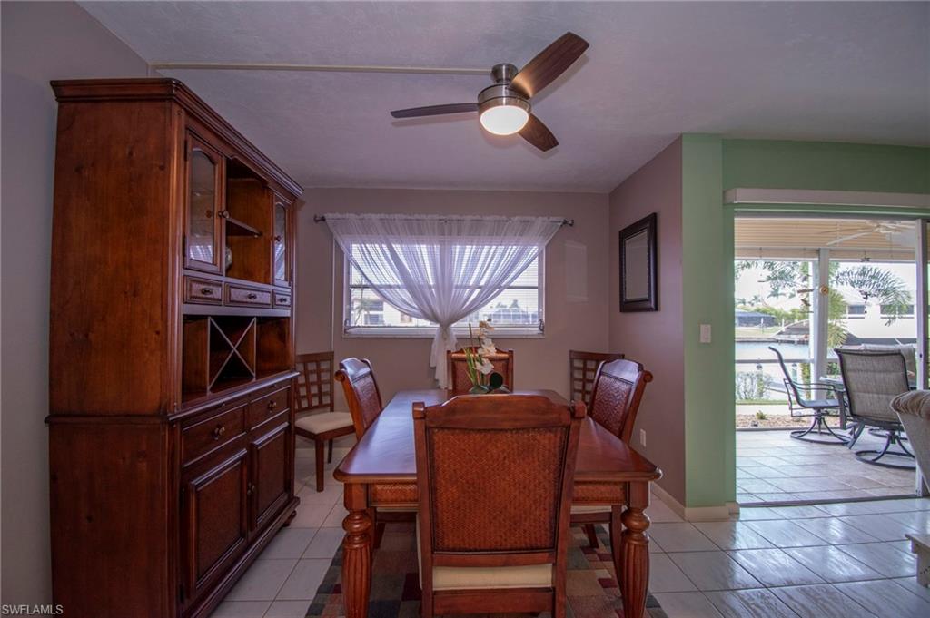 Dining space with light tile patterned floors and ceiling fan