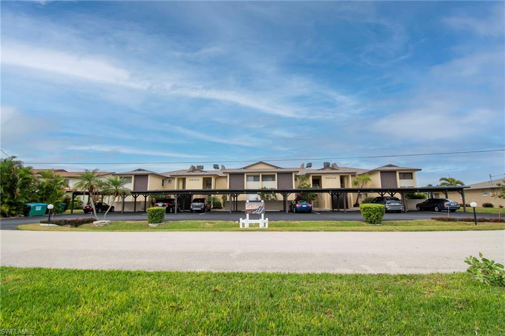 View of front of house featuring covered parking and a front lawn