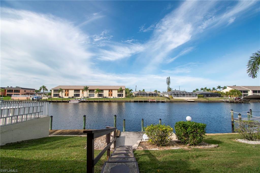 Dock with a yard, a residential view, and a water view