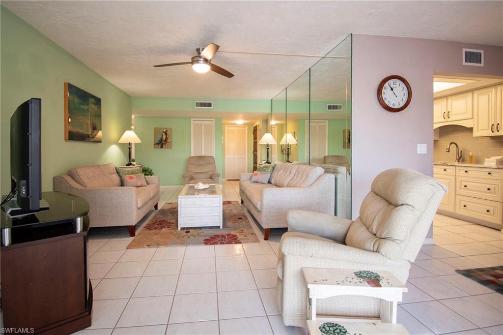 Living area featuring ceiling fan and light tile patterned flooring