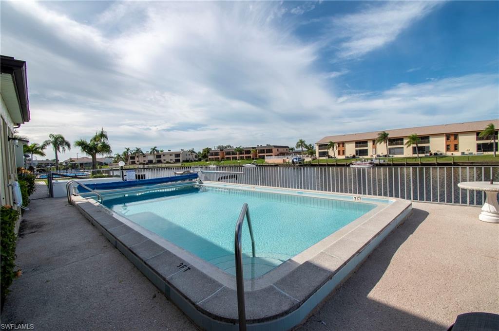 Community pool featuring a residential view, a patio, and a water view