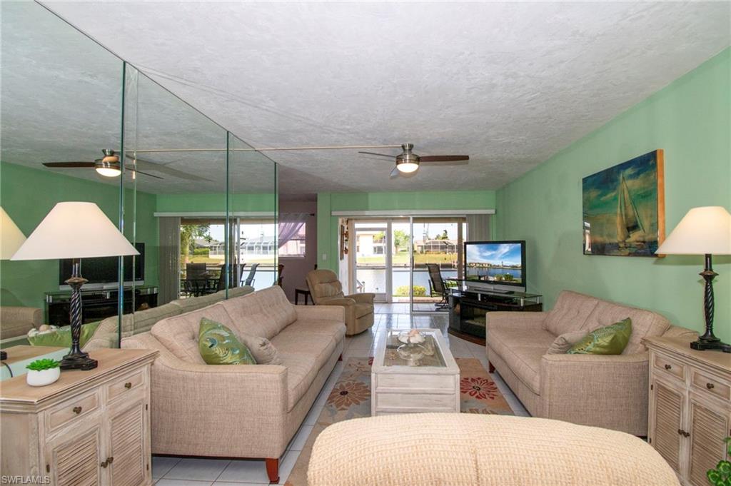 Tiled living area with plenty of natural light and ceiling fan