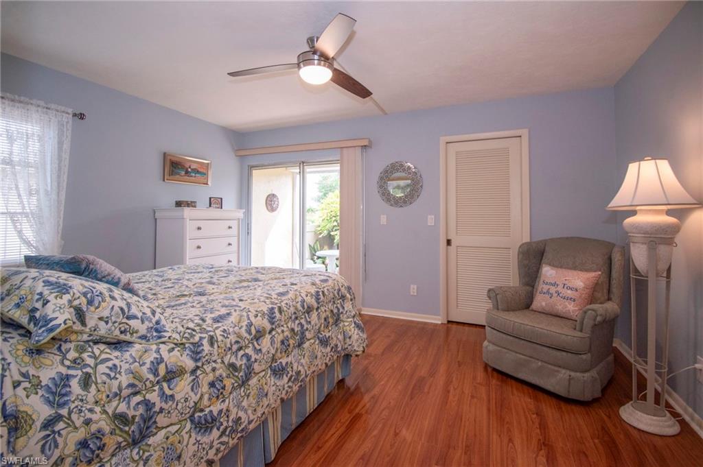 Bedroom with access to outside, wood finished floors, a ceiling fan, and a closet