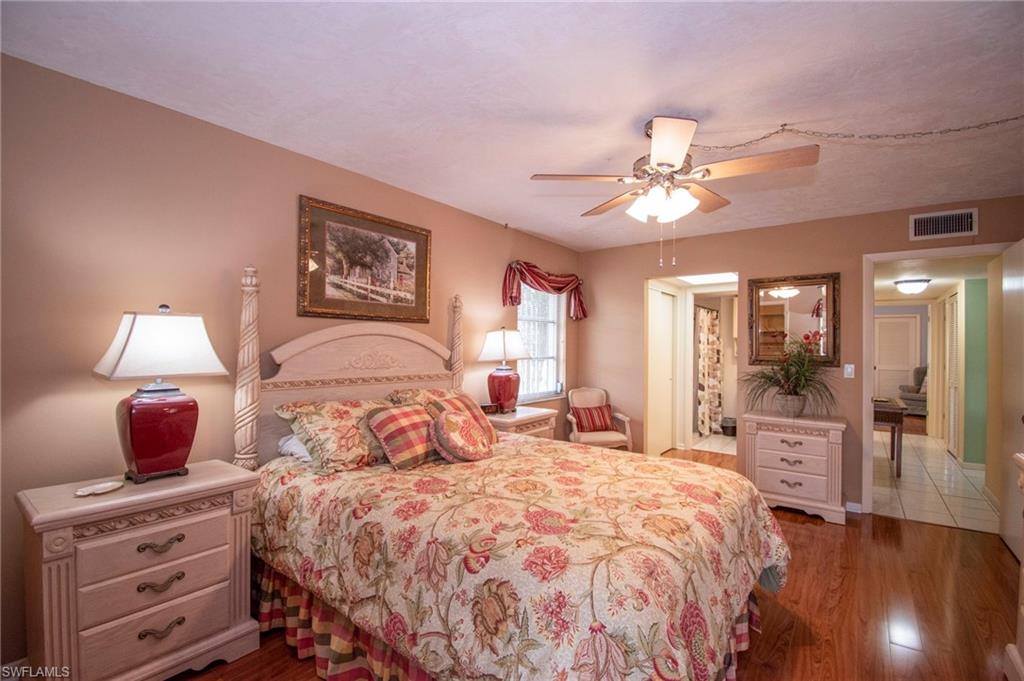 Bedroom featuring ensuite bathroom, dark wood finished floors, and a ceiling fan