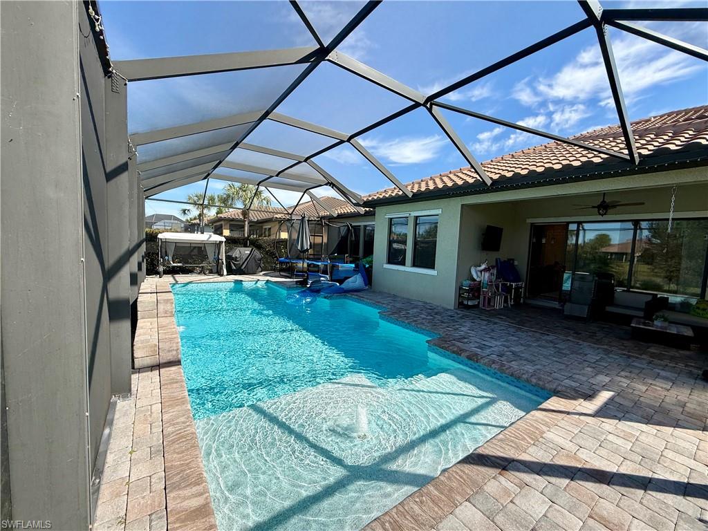 Swimming pool with a sunroom, a patio, and a lanai