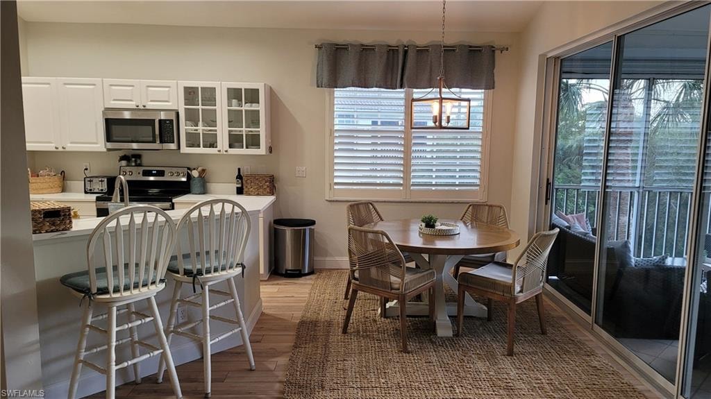 Dining space with light wood-style flooring and baseboards