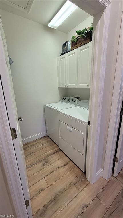 Laundry room with light wood finished floors, separate washer and dryer, and cabinet space