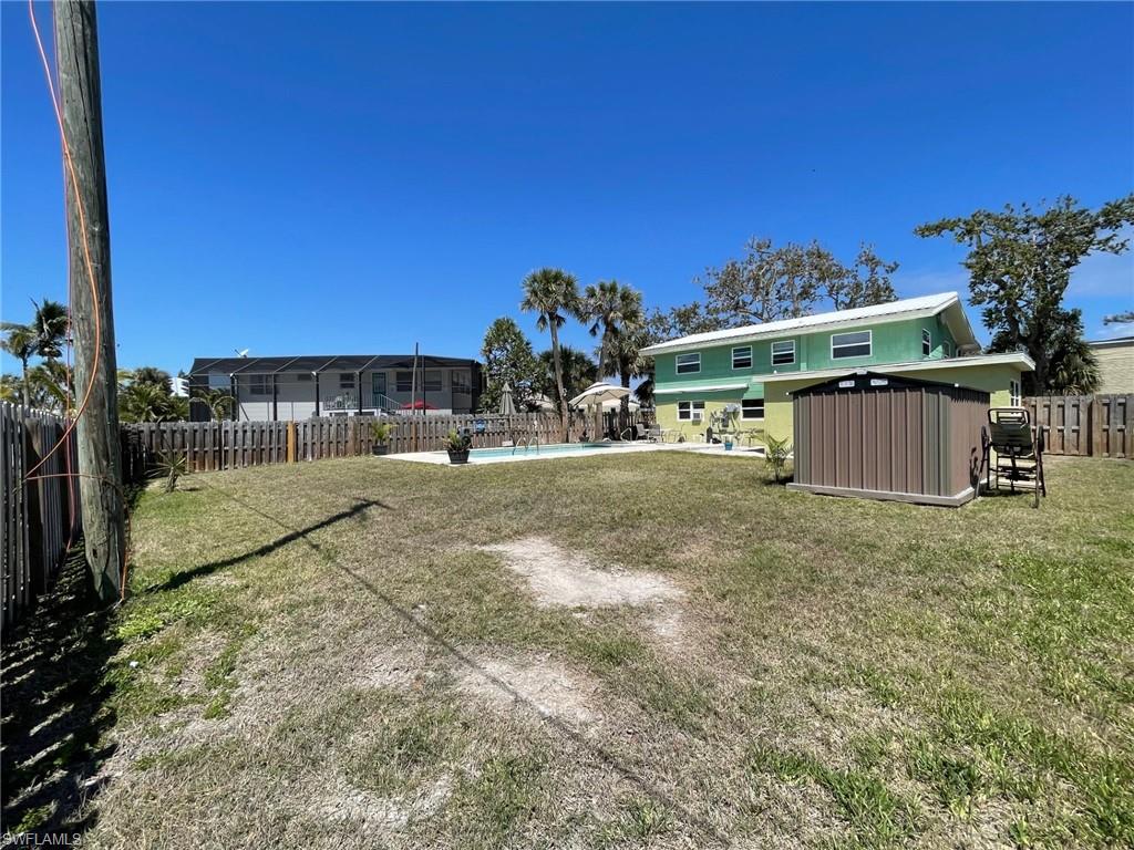 View of yard with an outbuilding, a fenced in pool, a storage shed, and a fenced backyard
