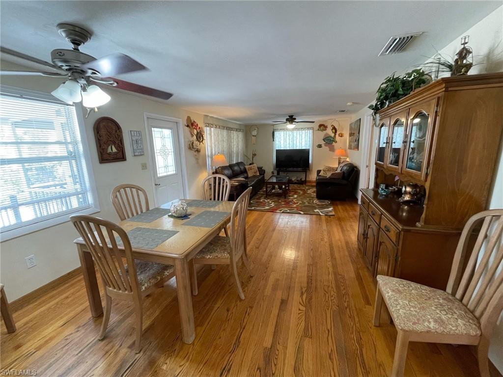 Dining space with new windows , oak wood floors and ceiling fan