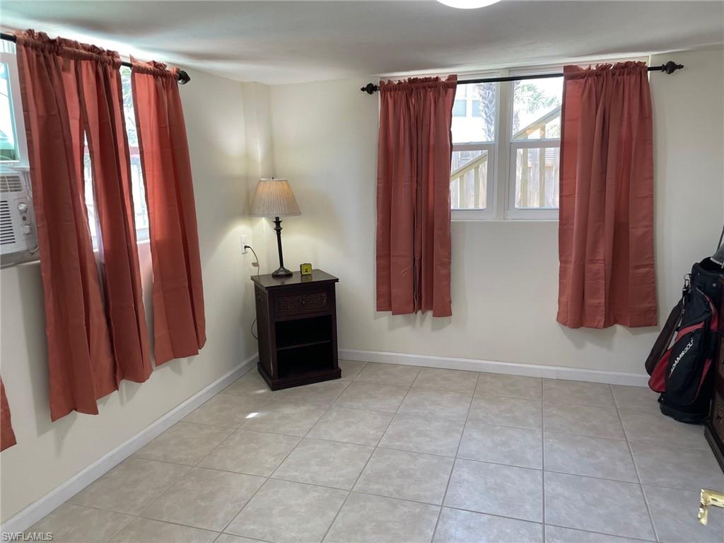 Bed room with light tile patterned floors and baseboards