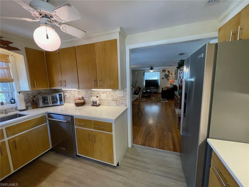 Kitchen featuring a sink, tasteful backsplash,Quartz countertops  , New appliances with stainless steel finish andwood type flooring