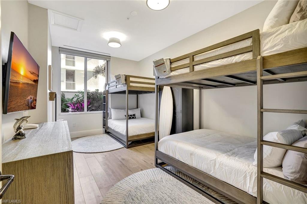 Third bedroom equipped with bunk beds, light wood-type flooring and baseboards