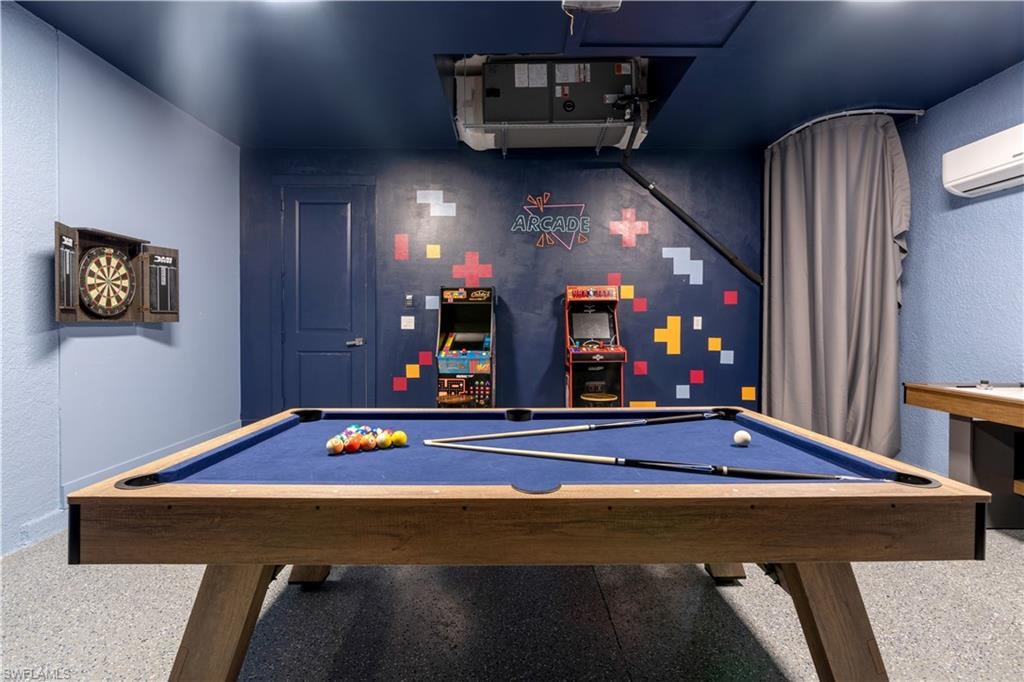 Rec room featuring a textured wall, billiards, and an AC wall unit