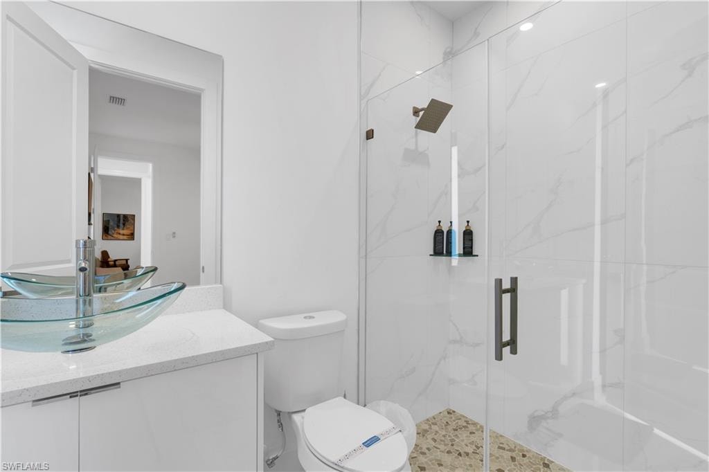 Full bathroom with vanity and a marble finish shower