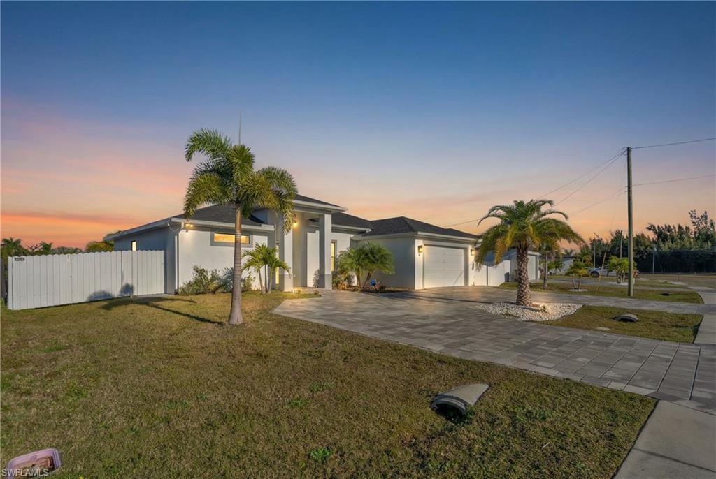 View of front of property with driveway and stucco siding