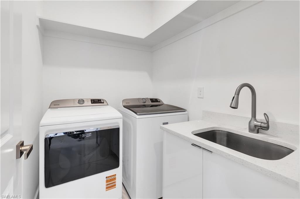 Laundry area featuring a sink and washing machine and clothes dryer