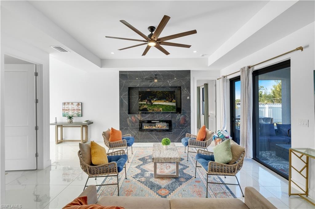 Living room featuring a premium fireplace and ceiling fan
