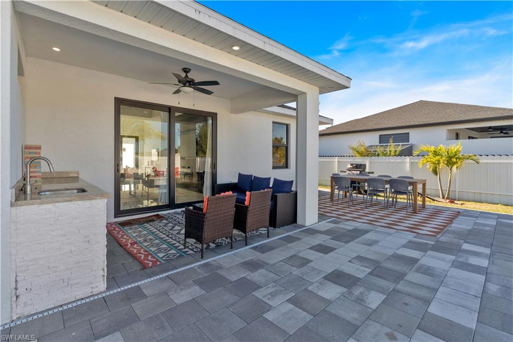 View of patio featuring outdoor dining space, ceiling fan, area for grilling, and an outdoor hangout area