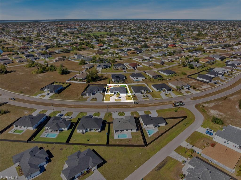 Aerial view of property and surrounding area featuring nearby suburban area