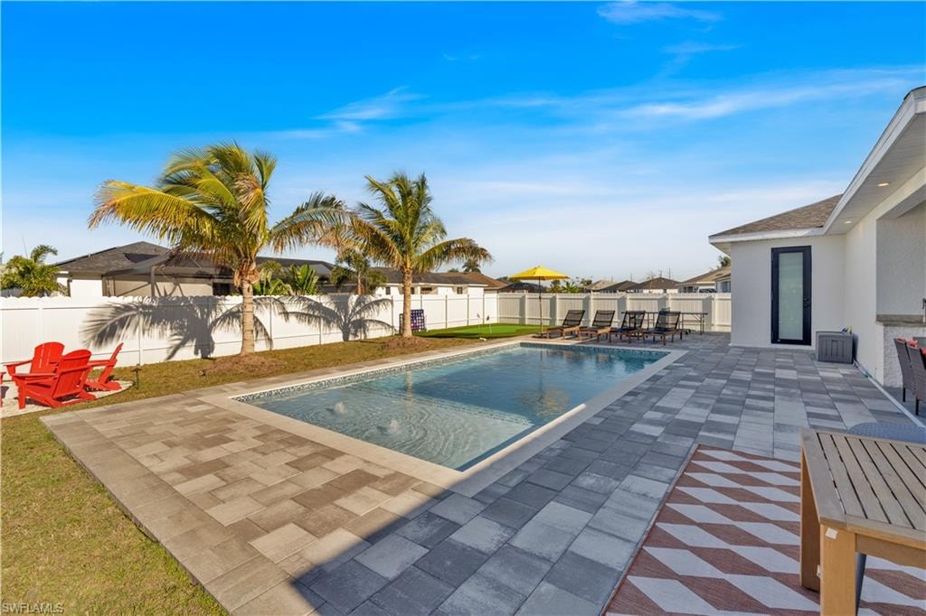 View of pool with a patio area, a fenced backyard, and a residential view