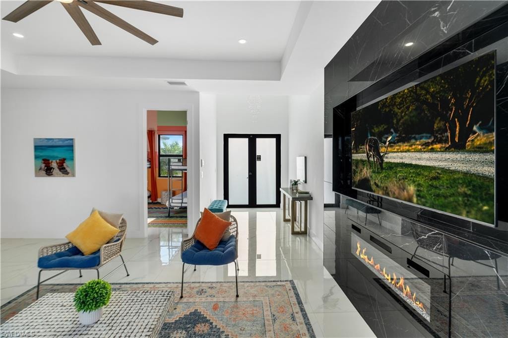 Living area with recessed lighting and a glass covered fireplace