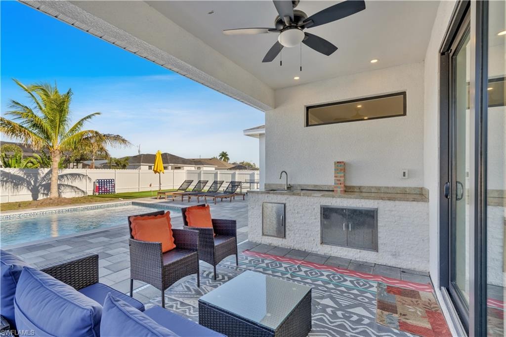 Fenced backyard with a patio area, outdoor lounge area, and ceiling fan