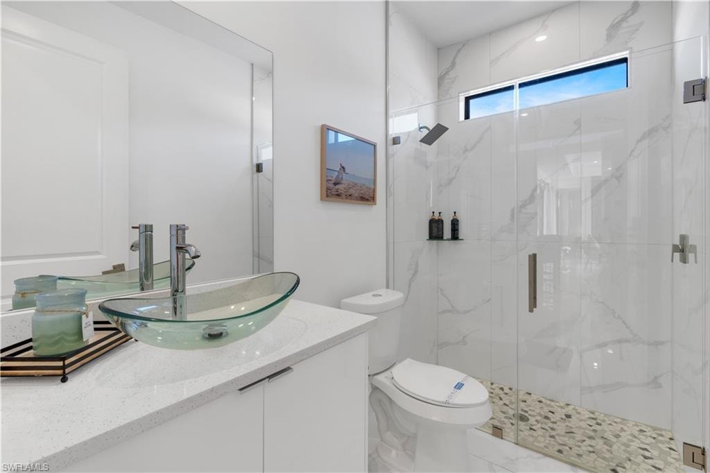 Full bathroom with vanity and a marble finish shower