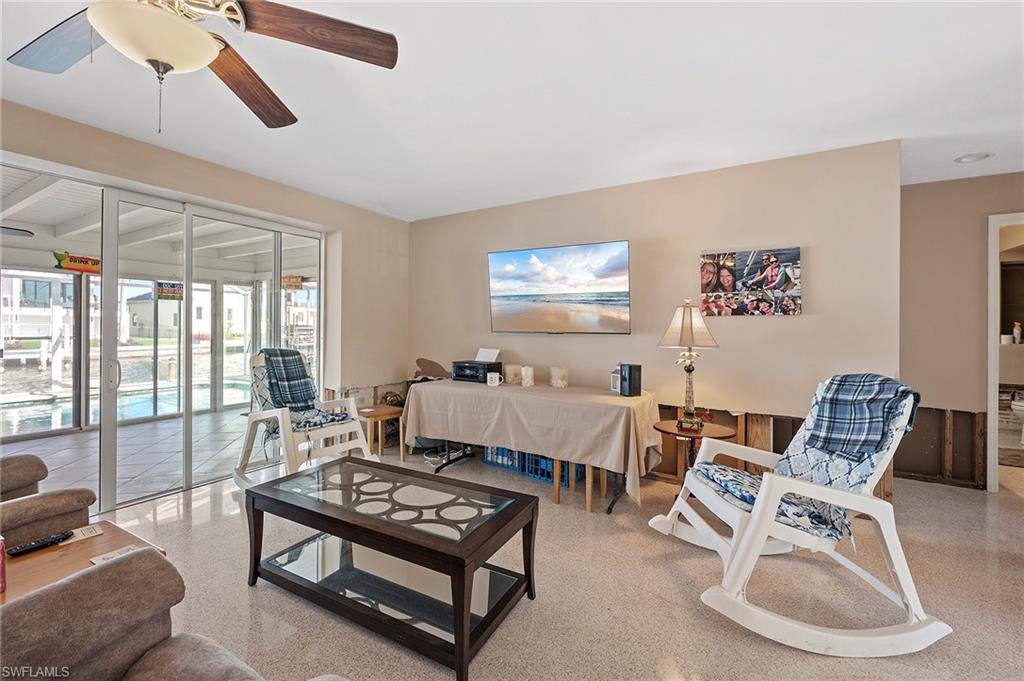 Living room with ceiling fan featuring terrazzo floor and drywall cut