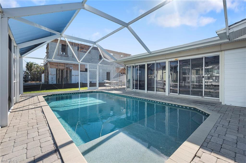 View of swimming pool with a patio and glass enclosure