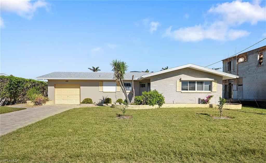 Single story home featuring a garage and a front yard