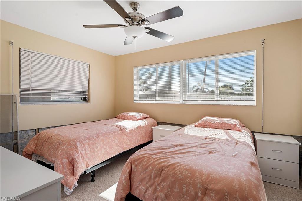 Terrazzo floor bedroom featuring ceiling fan and drywall cut