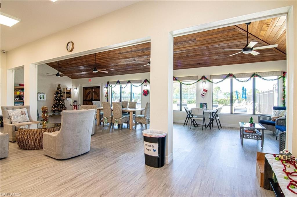Living room with wood-type flooring, vaulted ceiling, ceiling fan, and wood ceiling