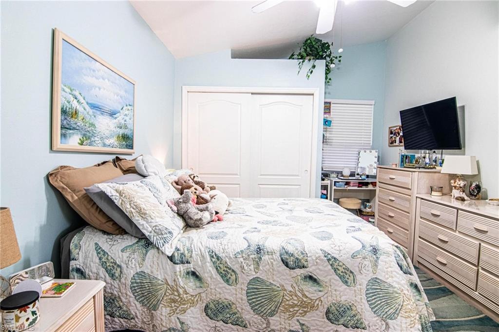 Bedroom with ceiling fan, a closet, and lofted ceiling