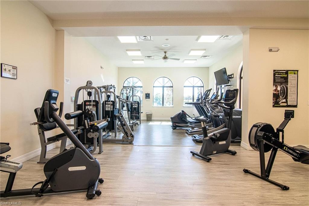 Gym with ceiling fan and light wood-type flooring
