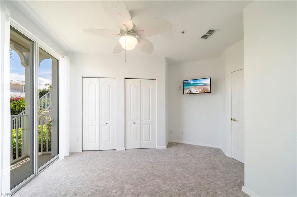 Unfurnished bedroom featuring two closets, access to exterior, light carpet, and a ceiling fan